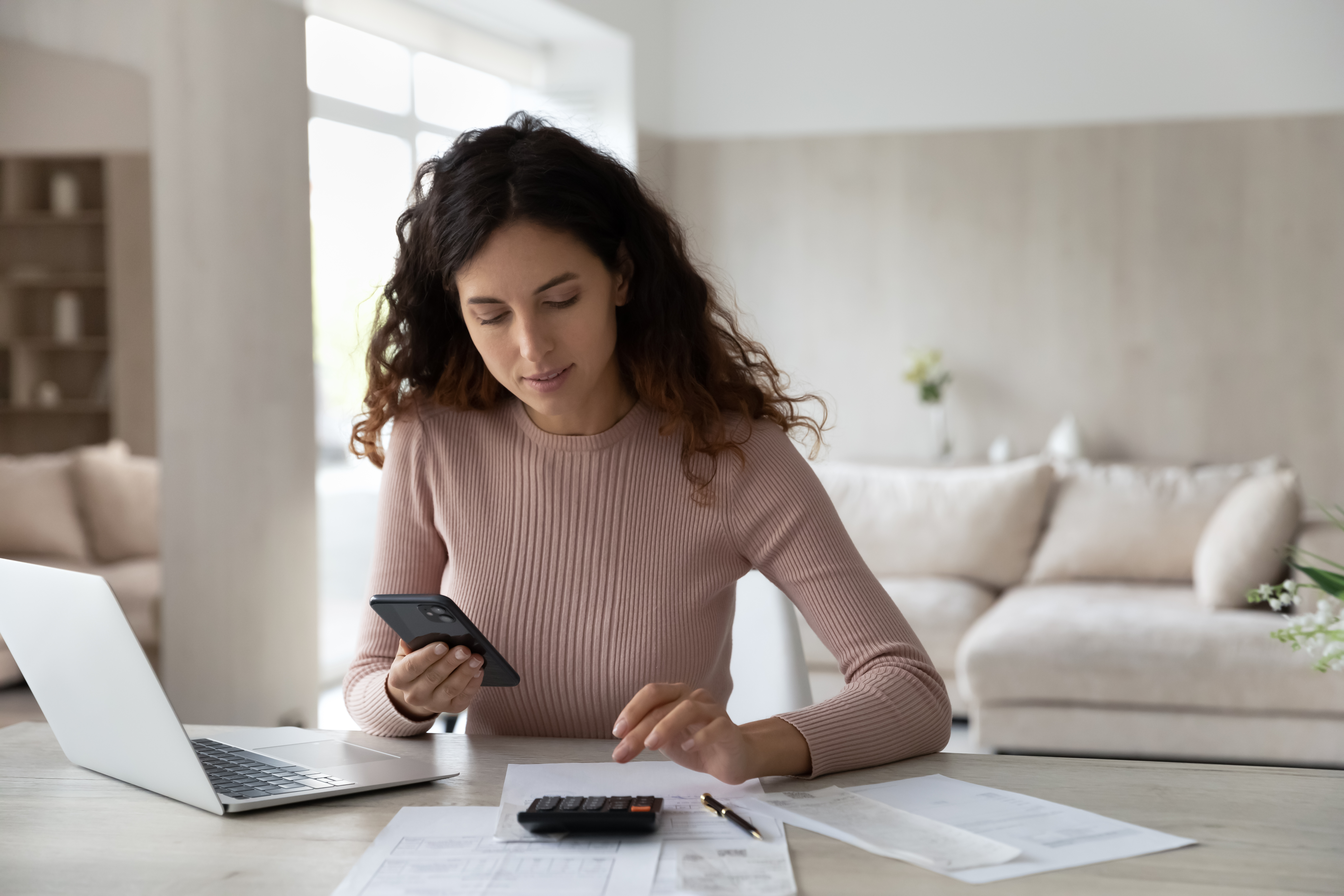 Woman calculating mortgage payments and checking credit score