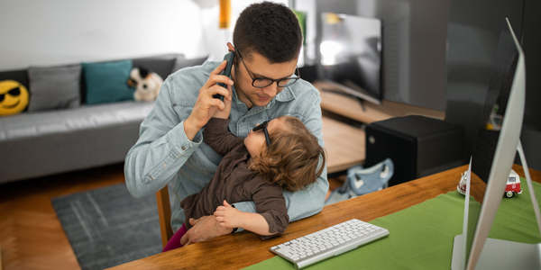 Person on the phone holding child