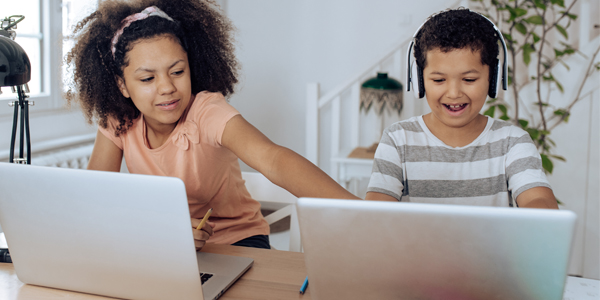 Two kids using cyber safe techniques on their laptops