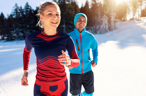 Two people running in snow