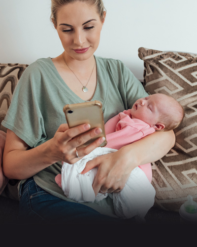 Parent with newborn on a cellphone