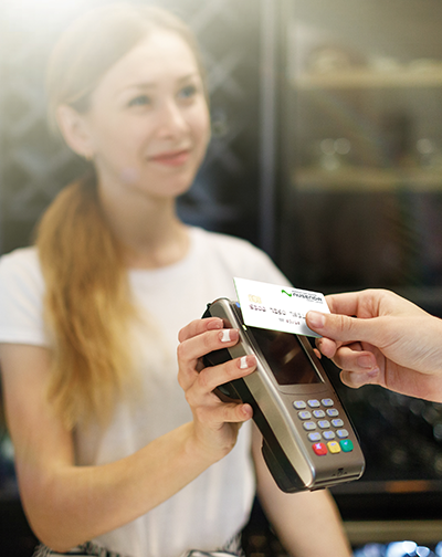 Woman holding credit machine to contactless Nusenda card